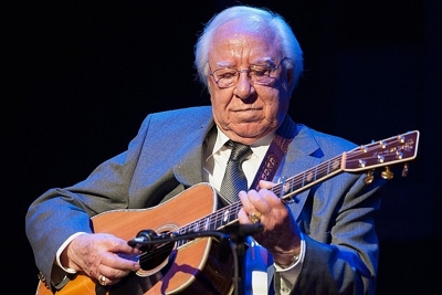 George Shuffler was born April 11, 1925 in Valdese, North Carolina to a large musical family. At age ten his father traded an old broken down car for a Kalamazoo guitar. At the age of 17, he was offered a job playing bass for the Bailey Brothers, and appeared with them on the Grand Ole Opry that same year. On December 28, 1950, Carter Stanley called and asked him to join the Stanley Brothers as bass player. Throughout the 1950s, Shuffler was primarily a bass player, but switched from the bass to guitar, and developed a style that changed the guitar from a side or rhythm instrument into a key component of bluegrass music. Shuffler perfected what would become his signature style of cross-picking. Shuffler worked with Don Reno and Bill Harrell until 1969, recording several albums with them on bass. In the early 1970s, he left the road to begin a new chapter of his musical career. For 22 years, he traveled and recorded with members of his family singing southern gospel music. He enjoyed recording “The Legacy Continues” with his protégé, the late James Alan Shelton, as well as “Mountain Treasures”, with his good friend and occasional musical partner, Asheville-based Laura Boosinger. In 1996 Shuffler was awarded the IBMA’s Distinguished Achievement Award. He was a 2007 recipient of the North Carolina Heritage award, and in 2011 he was inducted into the International Bluegrass Music Hall of Fame. He was also inducted into Bill Monroe’s Bluegrass Hall of Fame in 2013.